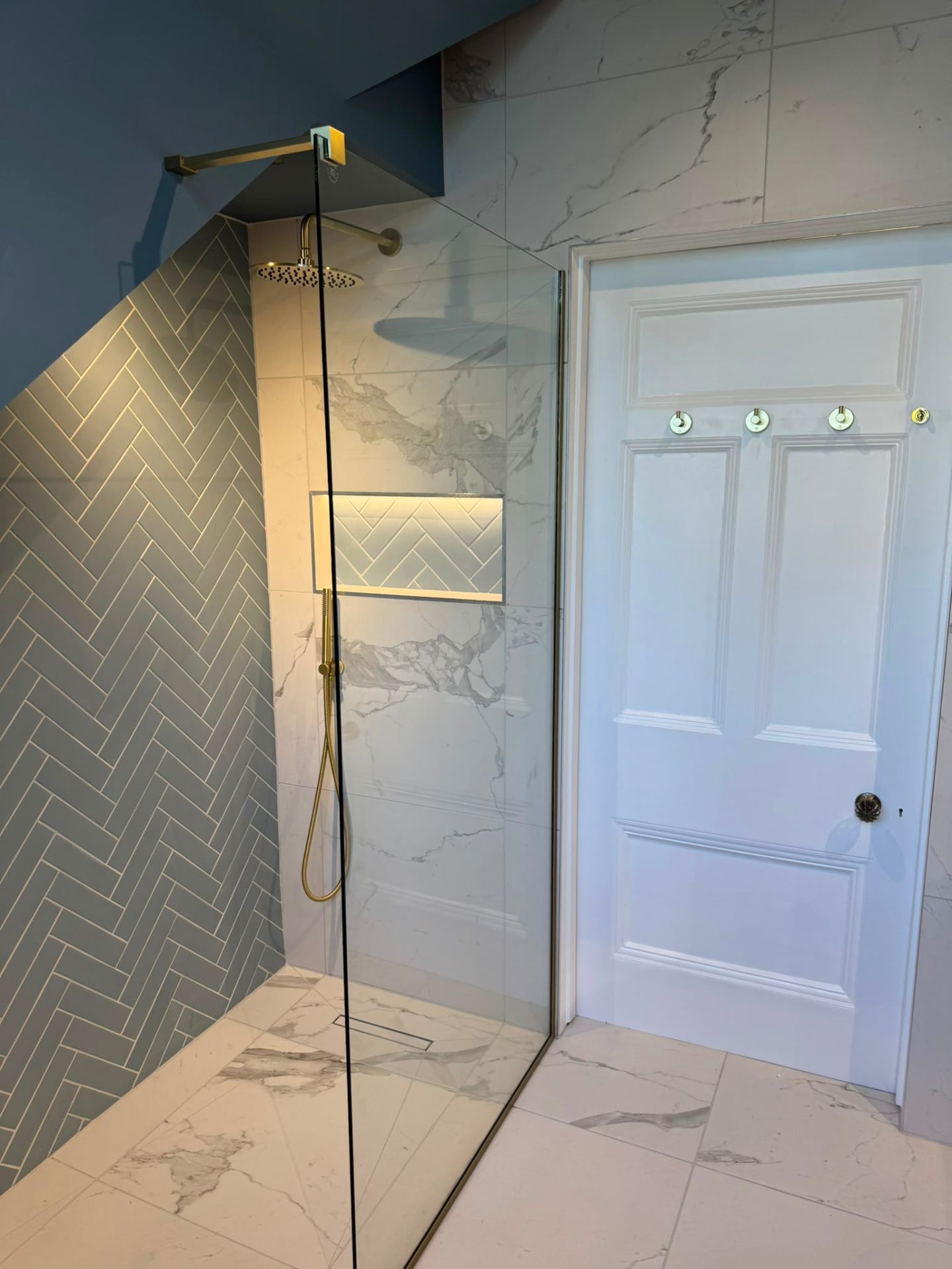 Walk-in marble shower enclosure fitted as part of a bathroom refurbishment in Surrey