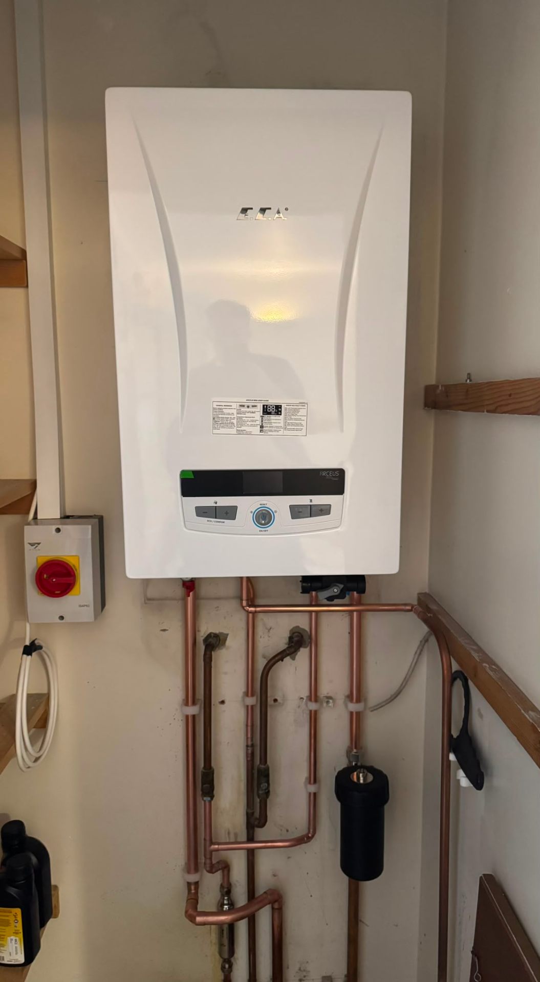 Wall-mounted combi boiler installation with condensate and gas pipework in Ashford